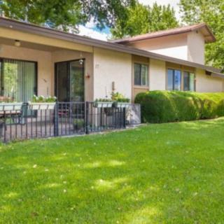 A charming residential house with a lush green lawn and cozy patio area.