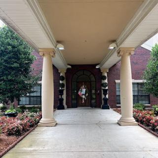 A grand entrance with elegant columns and well-maintained landscaping.