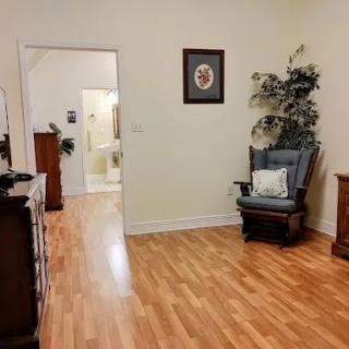 A cozy living room featuring wooden flooring, tasteful furniture, and decorative elements.