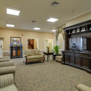 A cozy living room with sofas, armchairs, and a large entertainment center.