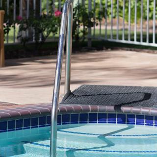 Close-up view of a swimming pool with steps and railing.