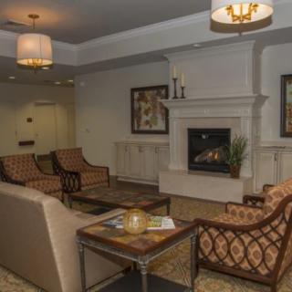 A cozy and elegantly decorated living room with a fireplace and comfortable seating.
