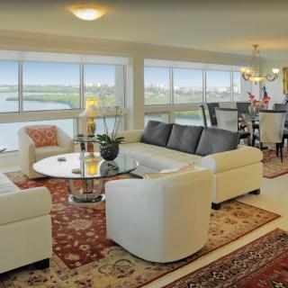 A spacious living room with elegant furnishings and large windows overlooking a scenic view.