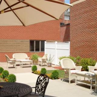A sunny outdoor patio with comfortable seating and a large umbrella.