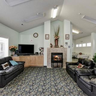 A cozy living room with a fireplace, television, and comfortable sofas.