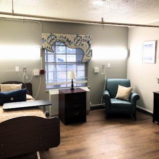 A cozy and well-lit room featuring a bed, seating area, and modern decor.