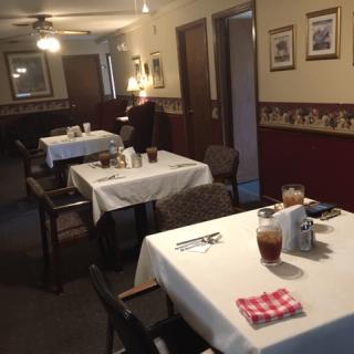 A cozy restaurant dining room with tables set for guests.