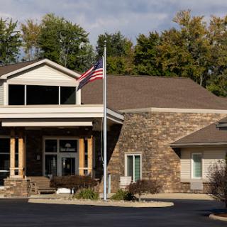 A welcoming building featuring a flag and a blend of stone and wood architecture.