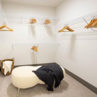 Minimalist dressing room with a bench and clothing hangers.