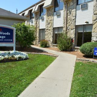 Entrance of a hotel with a neatly landscaped pathway and signage.