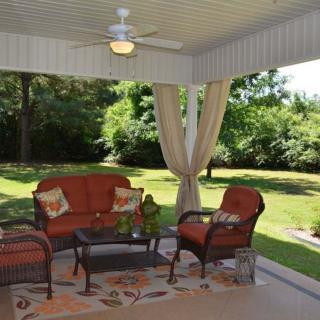 A cozy outdoor patio with comfortable seating overlooking a lush garden.