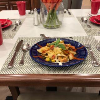 A beautifully set dinner table featuring a plate of pasta.