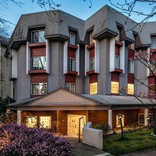 A modern residential building illuminated at dusk.
