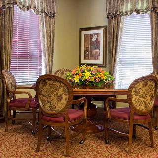 A cozy dining room with an elegant table set and floral centerpiece.