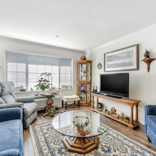 A cozy living room featuring comfortable seating, a glass coffee table, and a TV.