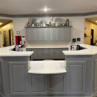 A modern reception area with a white counter and decorative elements.