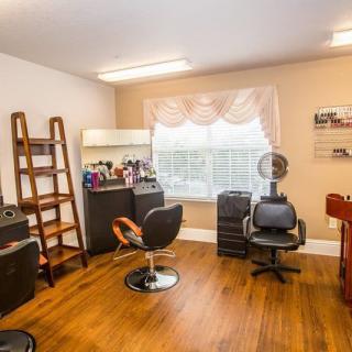 A cozy hair salon interior with styling chairs, a vanity mirror, and beauty products.