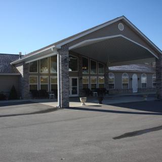 A motel entrance with a covered driveway and large windows.