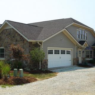 A modern suburban house featuring a stone facade and attached garage.