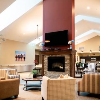 A modern living room with a central fireplace, skylights, and comfortable seating.