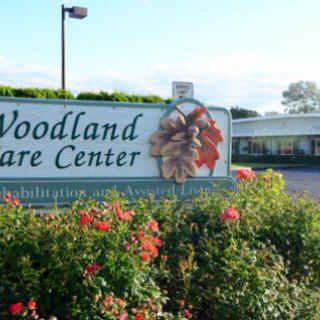 Entrance of Woodland Care Center with surrounding flowers.