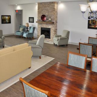 A spacious living room with a modern design, featuring comfortable seating and a cozy fireplace.