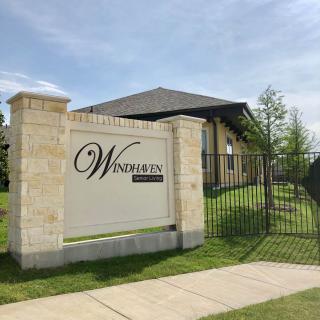 Entrance sign for a residential complex with a landscaped background.