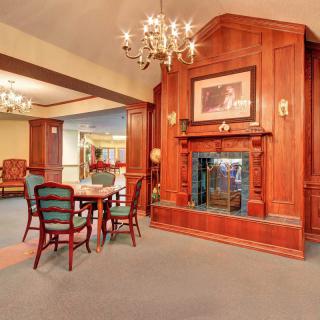 A cozy, traditionally designed room featuring a wooden fireplace and elegant furniture.