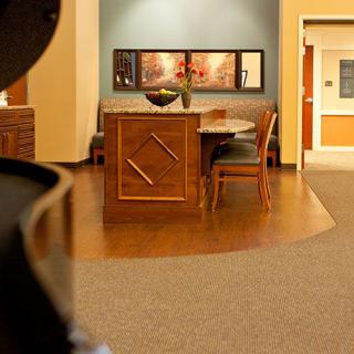 A warmly lit reception area with a desk and chairs, complemented by artwork on the wall.
