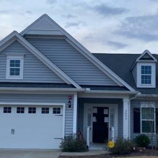 Front view of a suburban house with a garage and porch.