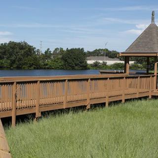 A wooden boardwalk and gazebo overlooking a peaceful lake.