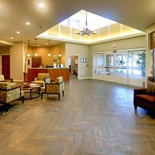 A spacious and well-lit lobby area with seating and a reception desk.