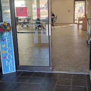 A welcoming entrance with a colorful sign inviting visitors inside.