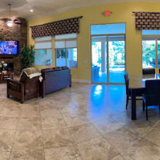 A spacious living area featuring modern furniture, tile flooring, and a view of the outdoors.