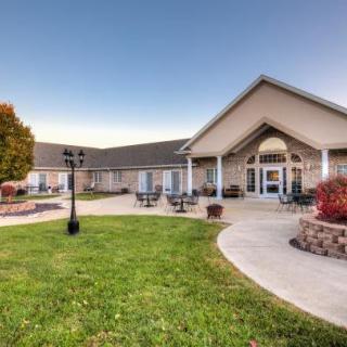 A well-maintained building with a large lawn and pathway on a clear day.