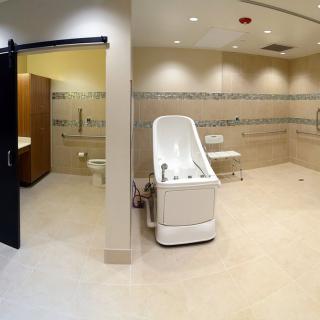 An accessible bathroom in a medical facility, equipped with a specialized bathtub and other necessary amenities.