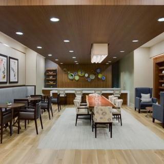 A modern lounge area featuring stylish furniture, wood flooring, and contemporary artwork.