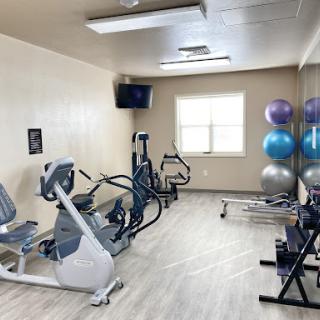 A well-equipped indoor gym featuring various exercise machines and fitness accessories.