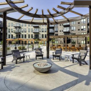 Modern outdoor seating area with a fire pit at an apartment complex.