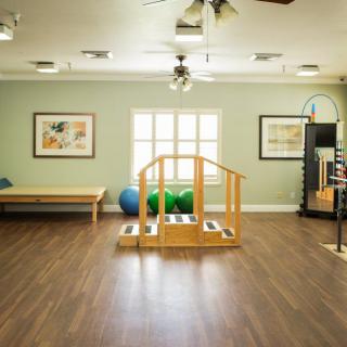 A well-equipped rehabilitation room featuring exercise equipment and a small indoor staircase for physical therapy exercises.