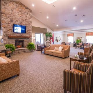 A cozy living room with a stone fireplace, sofas, and a television.