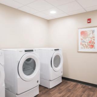 A modern laundry room with two front-loading washing machines.