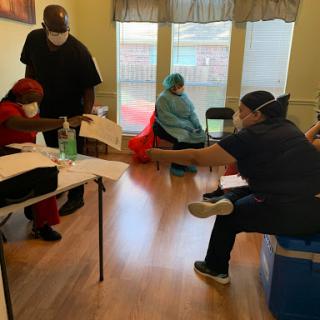 A healthcare setting where patients are receiving vaccinations with staff members observing safety protocols.