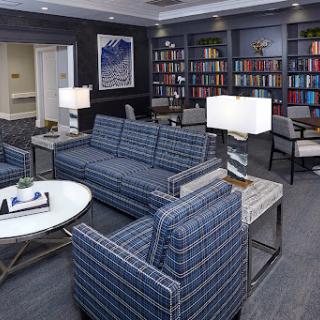 A modern living room featuring a stylish sofa, coffee table, and bookshelves filled with books.