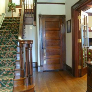 A beautifully designed home interior featuring a wooden staircase and classic doors.