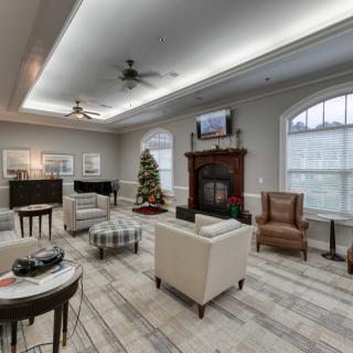 A spacious living room with modern decor, featuring a fireplace and a Christmas tree.