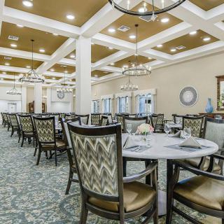 A spacious and elegantly decorated dining hall with neatly arranged tables and chairs.