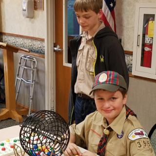 Two boys in scout uniforms enjoying a game of bingo.