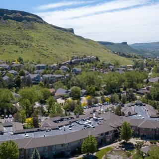 Aerial view of a town nestled among green hills, showcasing buildings and lush greenery.