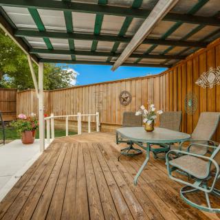 A cozy outdoor patio with a wooden deck and seating area under a cover.